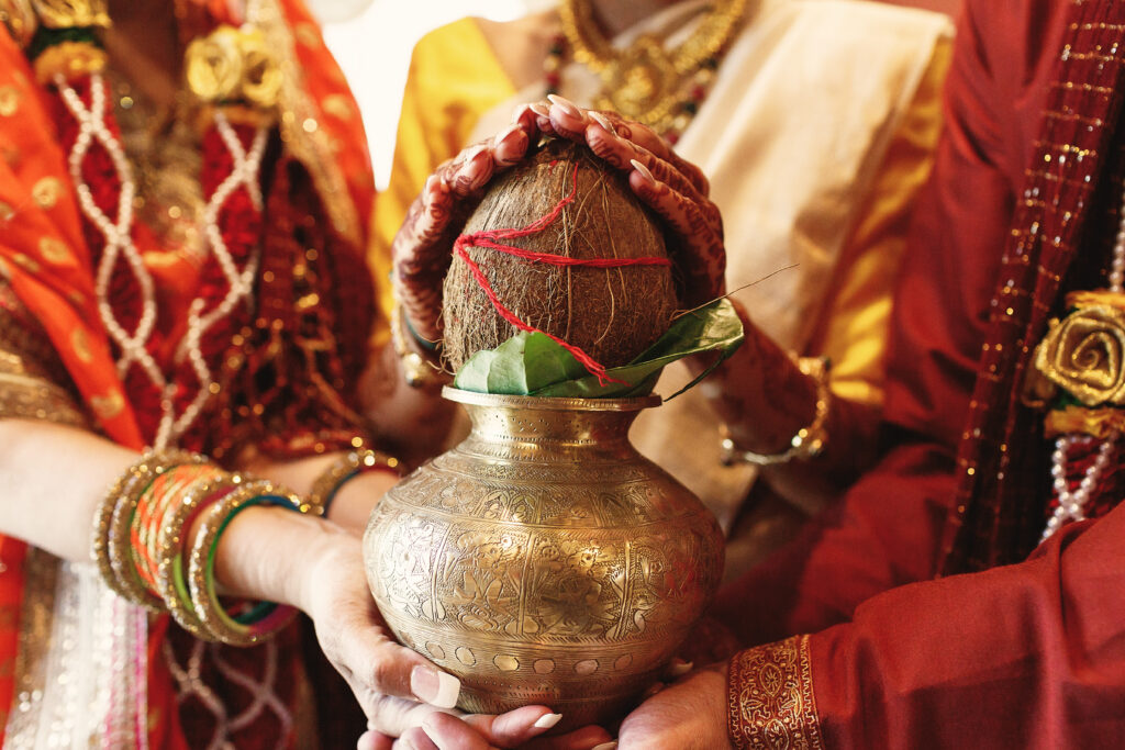 indian bride s parents hold bowl with coconut her hands